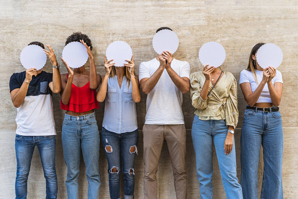 Jongeren verbergen hun gezicht. Communicatie, sociaal, netwerk, teamconcept. - Foto, afbeelding