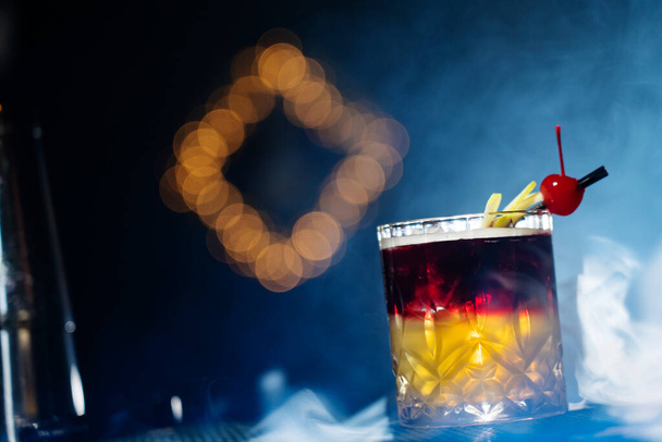 Koktajl alkoholowy w szklance z lodem w koncepcji napojów w klubie dymnym. Jeden kieliszek koktajlu. - Zdjęcie, obraz