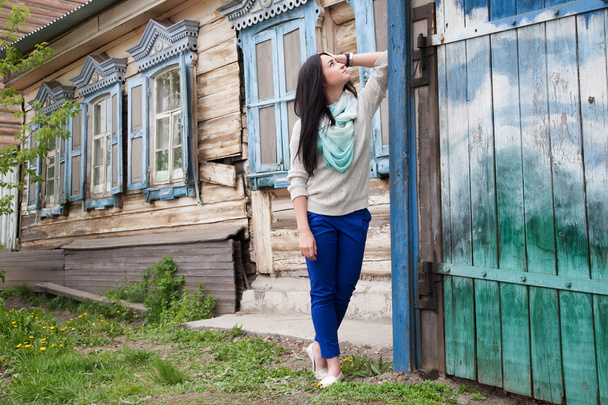 junges Mädchen auf dem Hintergrund des alten Holzhauses - Foto, Bild