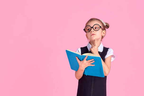 primary school girl in uniform, round glasses without lenses hol - Foto, imagen