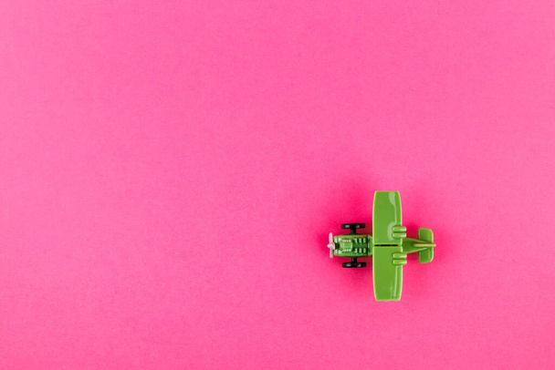 Small plastic airplane with copy space on pink background. Toy. - Foto, immagini