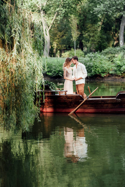 a boat trip for a guy and a girl along the canals and bays of the river overgrown with wild willows - Photo, Image