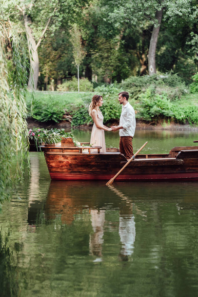 a boat trip for a guy and a girl along the canals and bays of the river overgrown with wild willows - Foto, Imagem