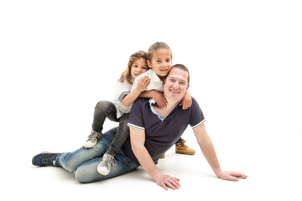 szczęśliwy młody biały ojciec bawiący się z małymi wielorasowymi dziećmi Szczęśliwy tata bawi się w zabawy z małymi wieloetnicznymi dziećmi. Koncepcja Dnia Ojca - Zdjęcie, obraz