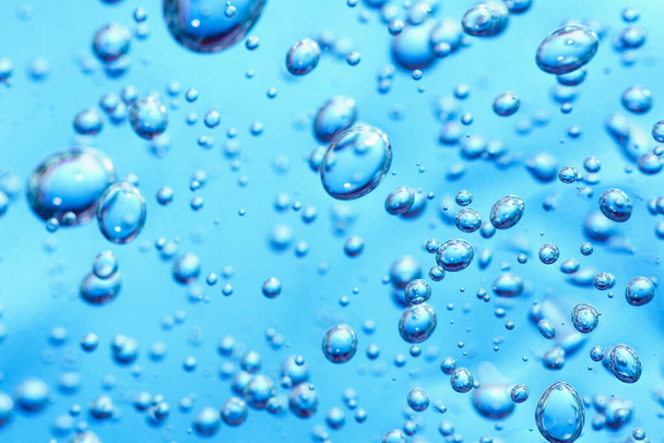 Close up macro gel di aloe vera texture cosmetica sfondo blu con bolle. Prodotto per la cura della pelle in gel di citronella. liquido antibatterico con aloe vera, idratante. Sicuro ed ecologico. - Foto, immagini
