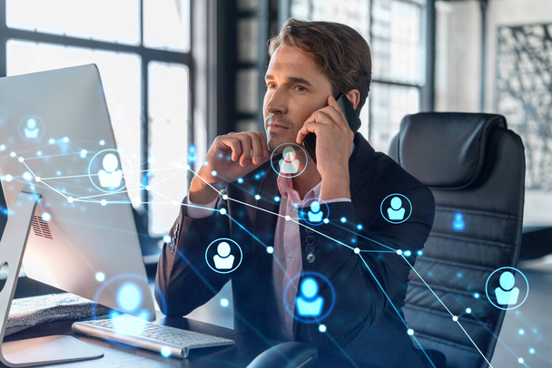 Businessman in suit has conference call to hire new employees for international business consulting. HR, social media hologram icons and interconnections over office background with panoramic windows - Photo, Image