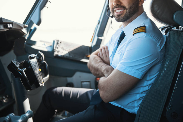 Zadowolony przystojny pilot w swoim miejscu pracy w dzień - Zdjęcie, obraz