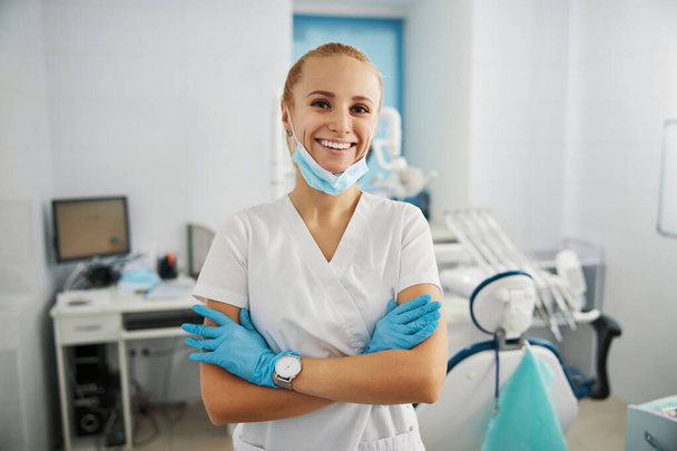 Cheerful doctor posing in her dental office for photo - Фото, зображення