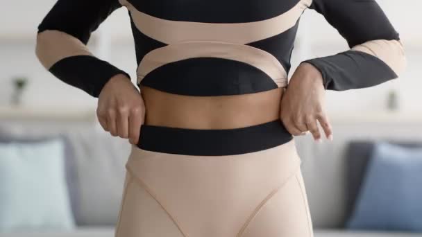 Mujer negra mostrando resultados de pérdida de peso y pantalones sobredimensionados interiores, recortados - Metraje, vídeo