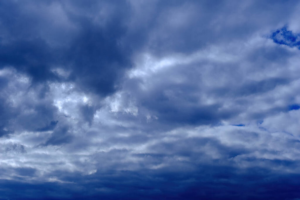впечатляющее глубокое голубое небо с пушистыми облаками, облачность в штормовую погоду, пасмурная атмосфера накануне шторма, прекрасный вид на кучевые облака, темное облачное небо, дождевые облака, естественный фон - Фото, изображение