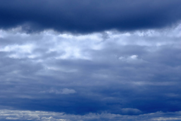 впечатляющее глубокое голубое небо с пушистыми облаками, облачность в штормовую погоду, пасмурная атмосфера накануне шторма, прекрасный вид на кучевые облака, темное облачное небо, дождевые облака, естественный фон - Фото, изображение