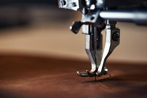 Working process of leather craftsman. Tanner or skinner sews leather on a special sewing machine, close up.worker sewing on the sewing machine - Photo, Image