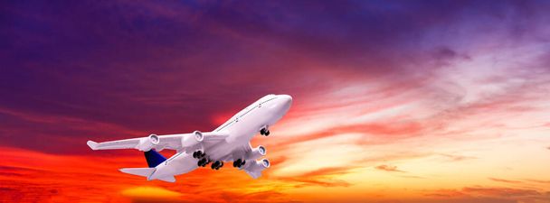 着陸機。白い旅客機の風景は、日没時に多色の雲と青空に飛んでいます。旅行の背景。旅客用航空会社。出張だ。民間航空機 - 写真・画像