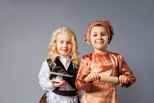 Kids pose in the costumes of a waiter and a cook - Φωτογραφία, εικόνα