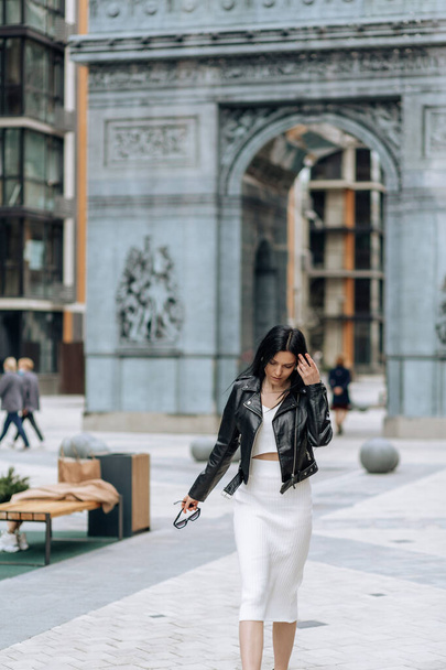 Young beautiful brunette fashionable outfit walking in the city - Foto, imagen