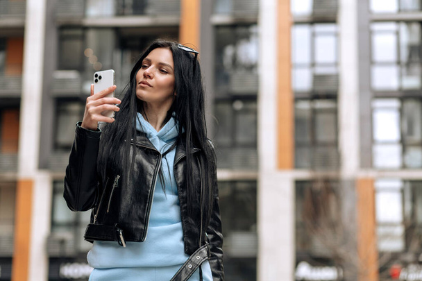Young beautiful brunette girl on the street makes a selfie on the phone - Foto, immagini