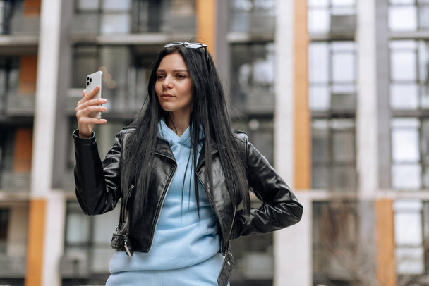 Young beautiful brunette girl on the street makes a selfie on the phone - Foto, immagini
