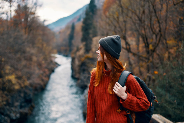 woman with backpack admires the river in the mountains nature - Photo, Image