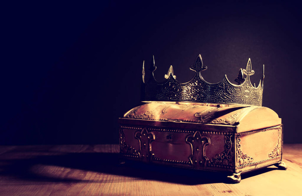 low key image of beautiful queen or king crown over gold treasure chest. vintage filtered. fantasy medieval period - Фото, зображення
