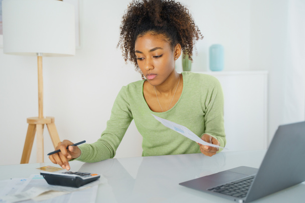 Black woman managing family budget at home table - Zdjęcie, obraz
