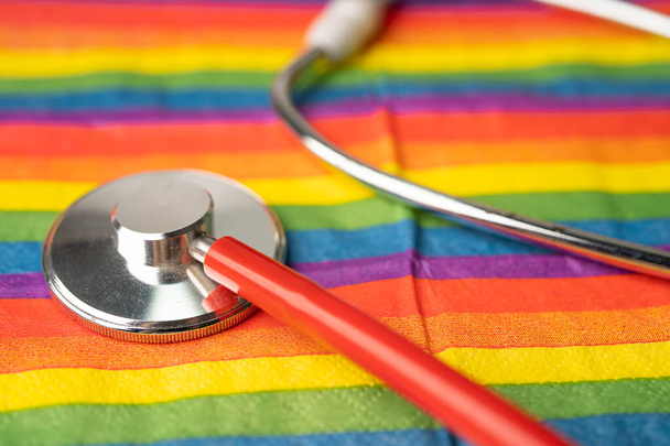 Black stethoscope on rainbow flag background, symbol of LGBT pride month celebrate annual in June social, symbol of gay, lesbian, bisexual, transgender, human rights and peace. - Photo, Image