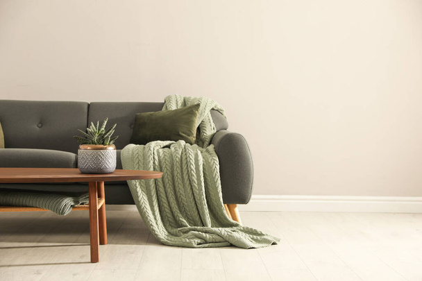 Κομψό άνετο καναπέ στο δωμάτιο, χώρο για κείμενο. Εσωτερική διαρρύθμιση - Φωτογραφία, εικόνα