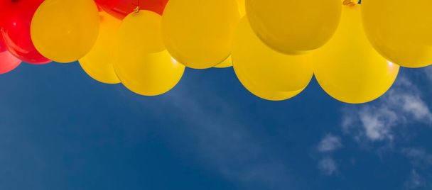 Blue sky with yellow and red balloons - Foto, imagen