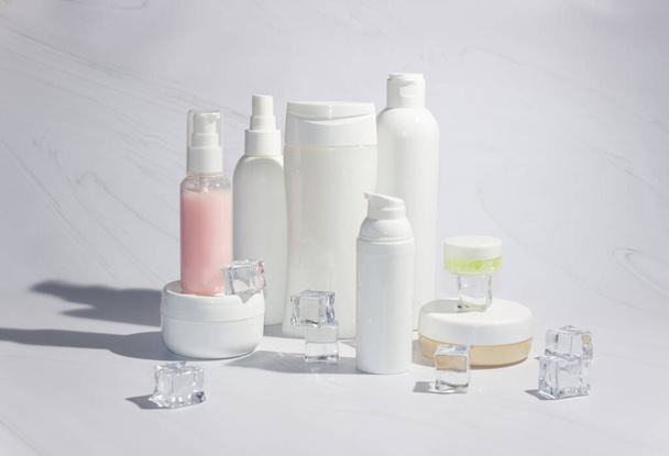 Weiße Flaschen und Dosen für Kosmetika auf hellem Hintergrund. Sauberkeit, Layout und Vorlage - Foto, Bild