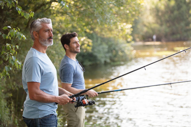 friends men with fishing rod at the river - Foto, Imagem