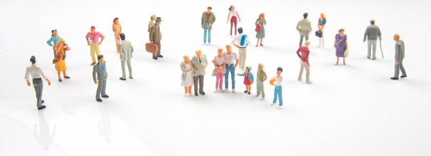 miniature people. different people stand on a white background. communication of society of different generations - Photo, Image