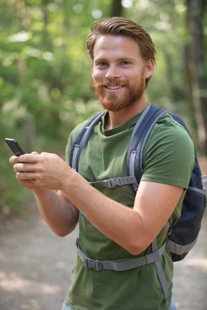 hiker man with mountain backpacker making phone call - Foto, Imagem