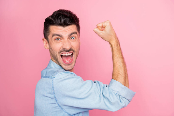 Profiel side photo of victorious happy cheerful guy raise vuist sterke schreeuw geïsoleerd op pastel roze kleur achtergrond - Foto, afbeelding