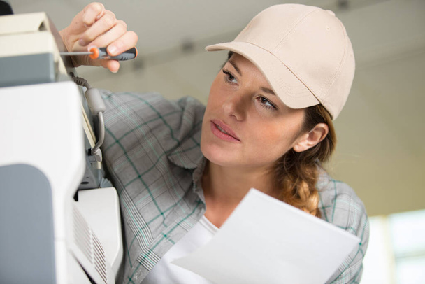 woman repairing photocopier using screwdriver - Foto, immagini