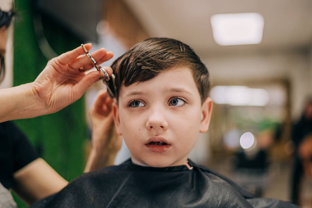 Haircut for little kid boy, professional barber doing haircut. Hairdress for children - Zdjęcie, obraz