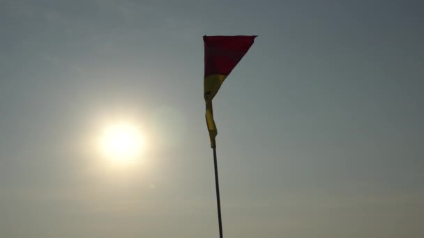 Красный и желтый флаг на пляже. - Кадры, видео
