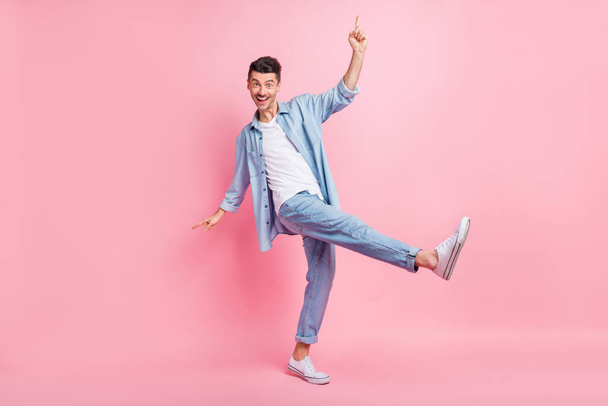 Full length body size photo of positive millennial dancing at party wearing casual denim clothes isolated on pastel pink color background - Foto, Bild