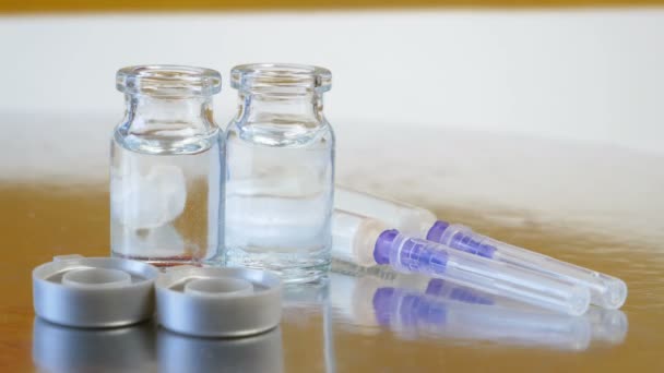 butelki w szczepionce i strzykawkach ze szczepionką na tle flagi Niemiec, szczepionka przeciwko koronawirusowi covid-19, zbliżenie - Materiał filmowy, wideo