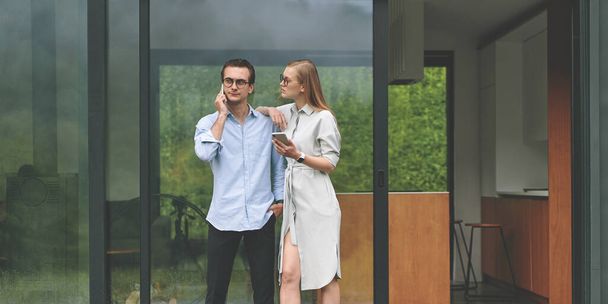 Front view of young business couple working on the terrace with smartphones - Valokuva, kuva
