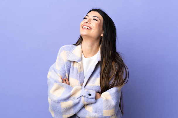 Junge brünette Frau über isolierten lila Hintergrund glücklich und lächelnd - Foto, Bild