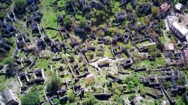Olludeniz yakınlarındaki dünyaca ünlü Kayakoy hayalet kasabasının insansız hava aracı görüntüsü, Fethiye. Tepenin güzel yeşil yamacındaki antik şehir.. - Video, Çekim