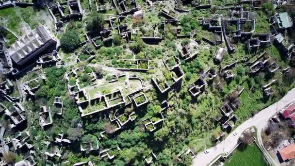 Olludeniz yakınlarındaki dünyaca ünlü Kayakoy hayalet kasabasının insansız hava aracı görüntüsü, Fethiye. Tepenin güzel yeşil yamacındaki antik şehir.. - Video, Çekim