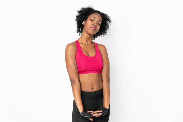 Jonge Afro-Amerikaanse vrouw geïsoleerd op witte achtergrond stretching arm - Foto, afbeelding