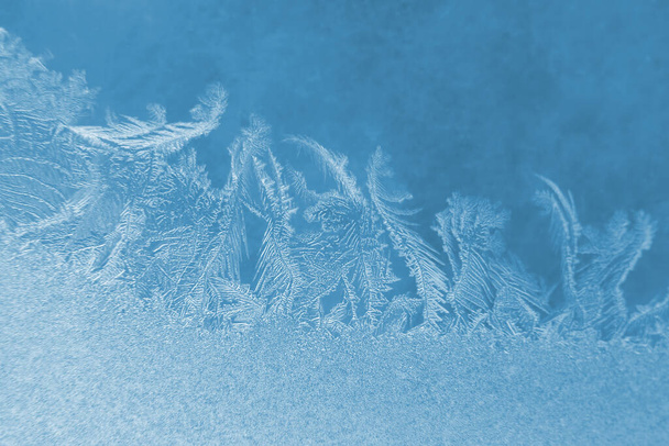 Frostige Muster auf der Fensterscheibe Nahaufnahme. natürliche Texturen und Hintergründe. Eismuster auf gefrorenen - Foto, Bild