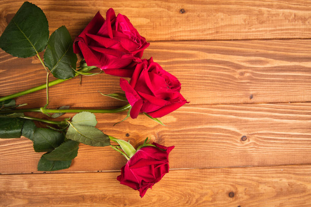 красные розы на деревянном фоне - Фото, изображение