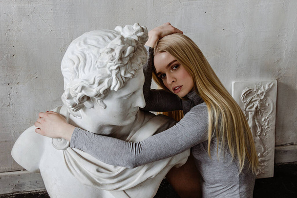 Beautiful woman posing with antique sculpture - Fotoğraf, Görsel