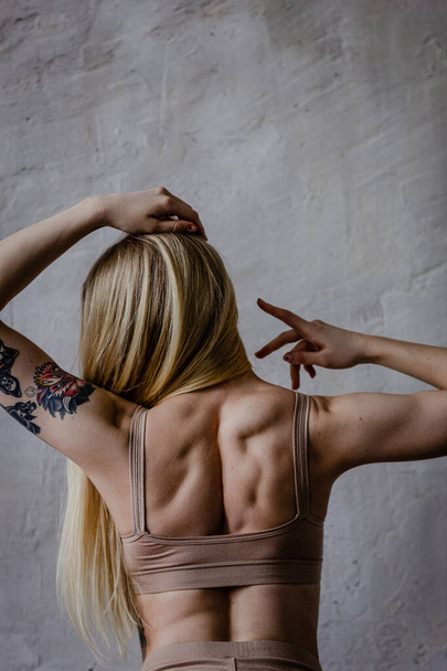 Back view of fit tattooed woman - Foto, afbeelding