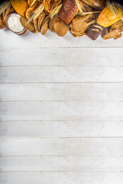 Ассортимент разнообразных вкусных свежеиспеченных хлебов, на белом фоне - Фото, изображение