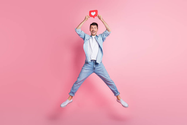Full size photo of handsome amazed man jump up star shape hold like icon above head isolated on pink color background - Fotoğraf, Görsel