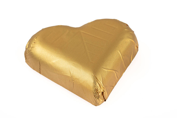Chocolate dorado. Aislar la forma del corazón de chocolate organizar sobre el fondo blanco. - Foto, Imagen