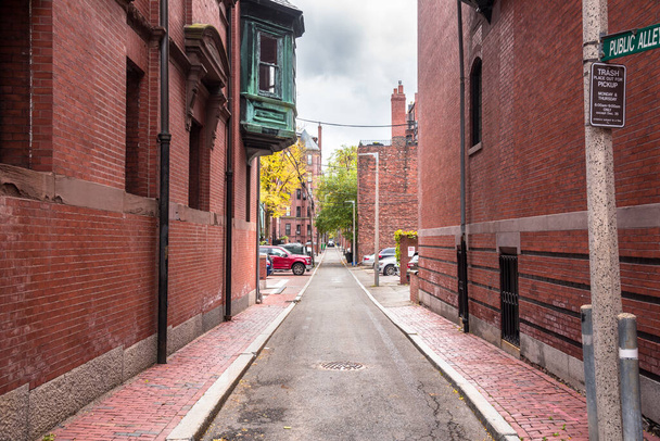 Narrow alley between brick buildings in historic neighbourhood on a stormy autumn day. Boston, MA, USA. - Photo, image